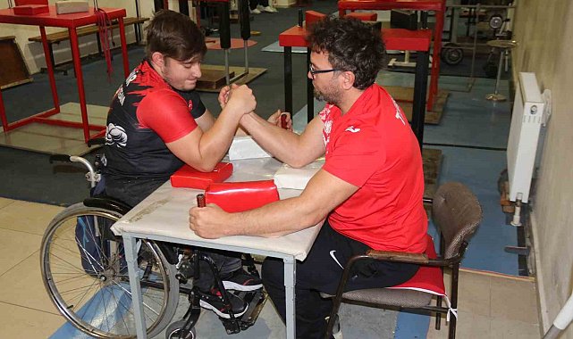 Aynı engele sahip olan öğrencisi ile bilek güreşi yapıyor