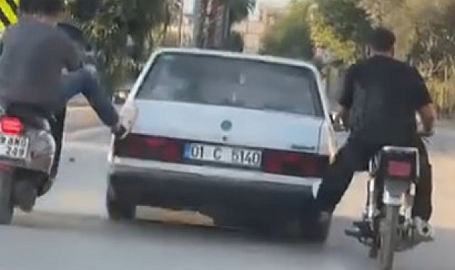 Motosikletliler, yolda kalan otomobili ayaklarıyla ittirdi